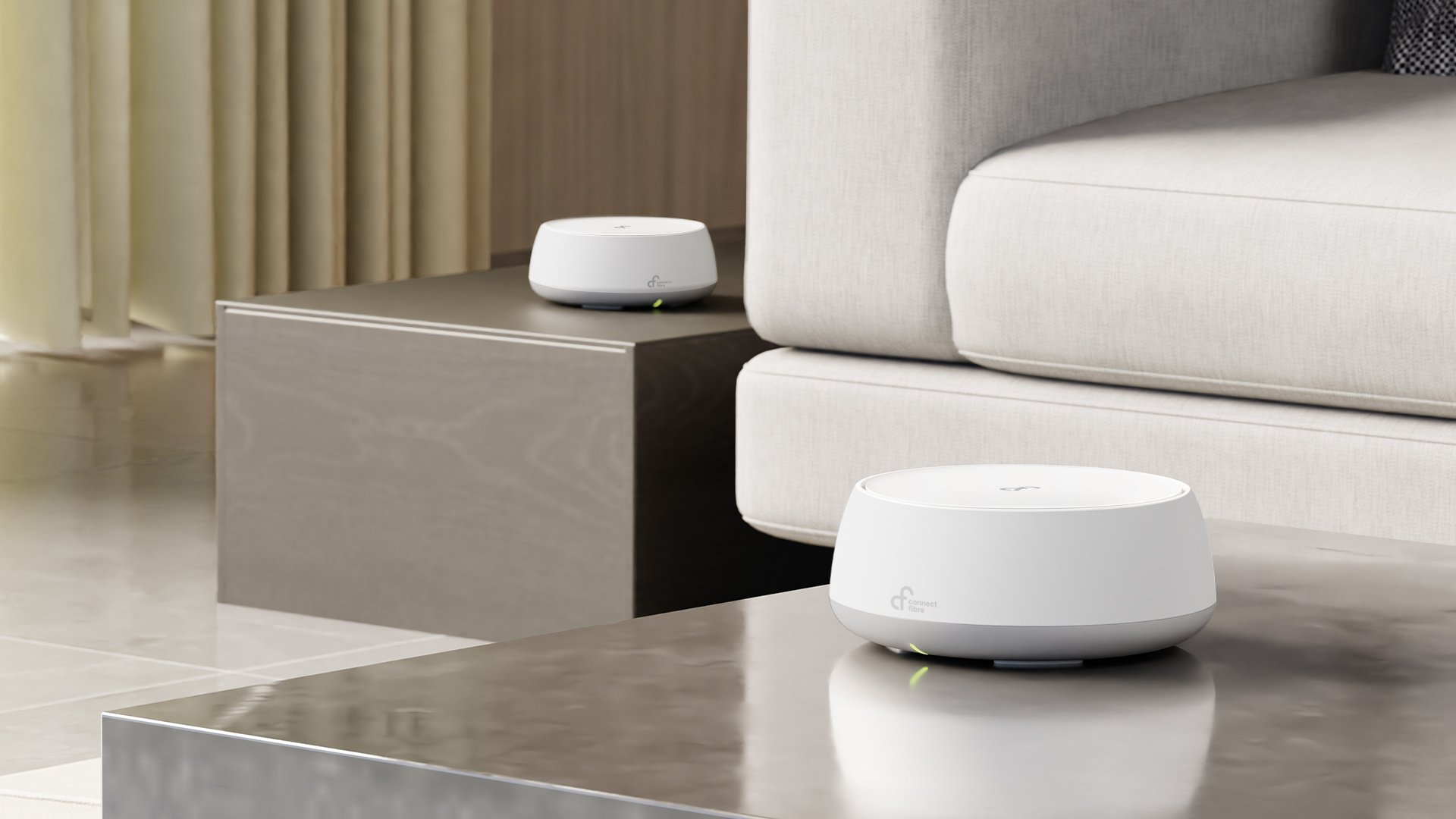 Two white mesh routers sat on sleek side tables beside a light-colored sofa in a stylish living room setting.