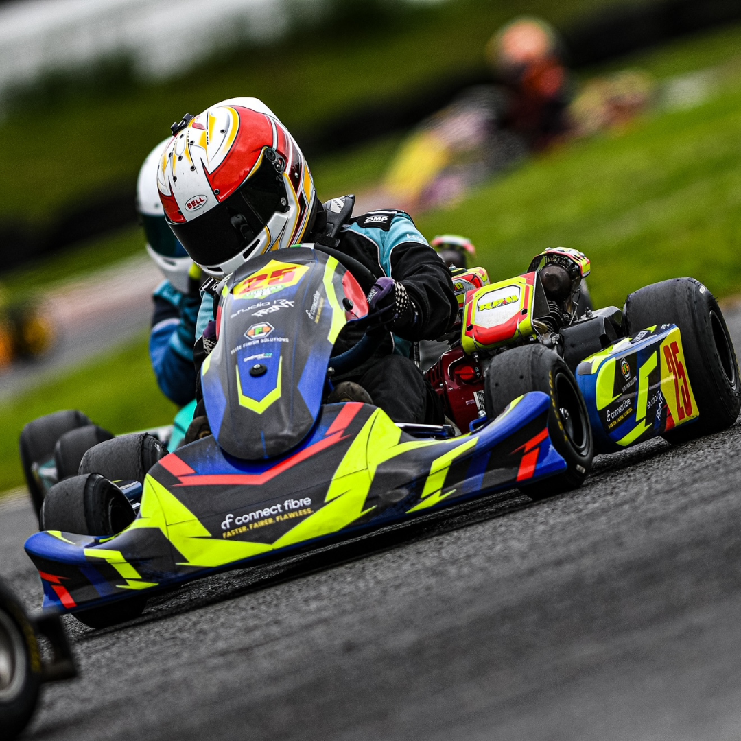 A racing car being driven by a racer with Connect Fibre on the front of it