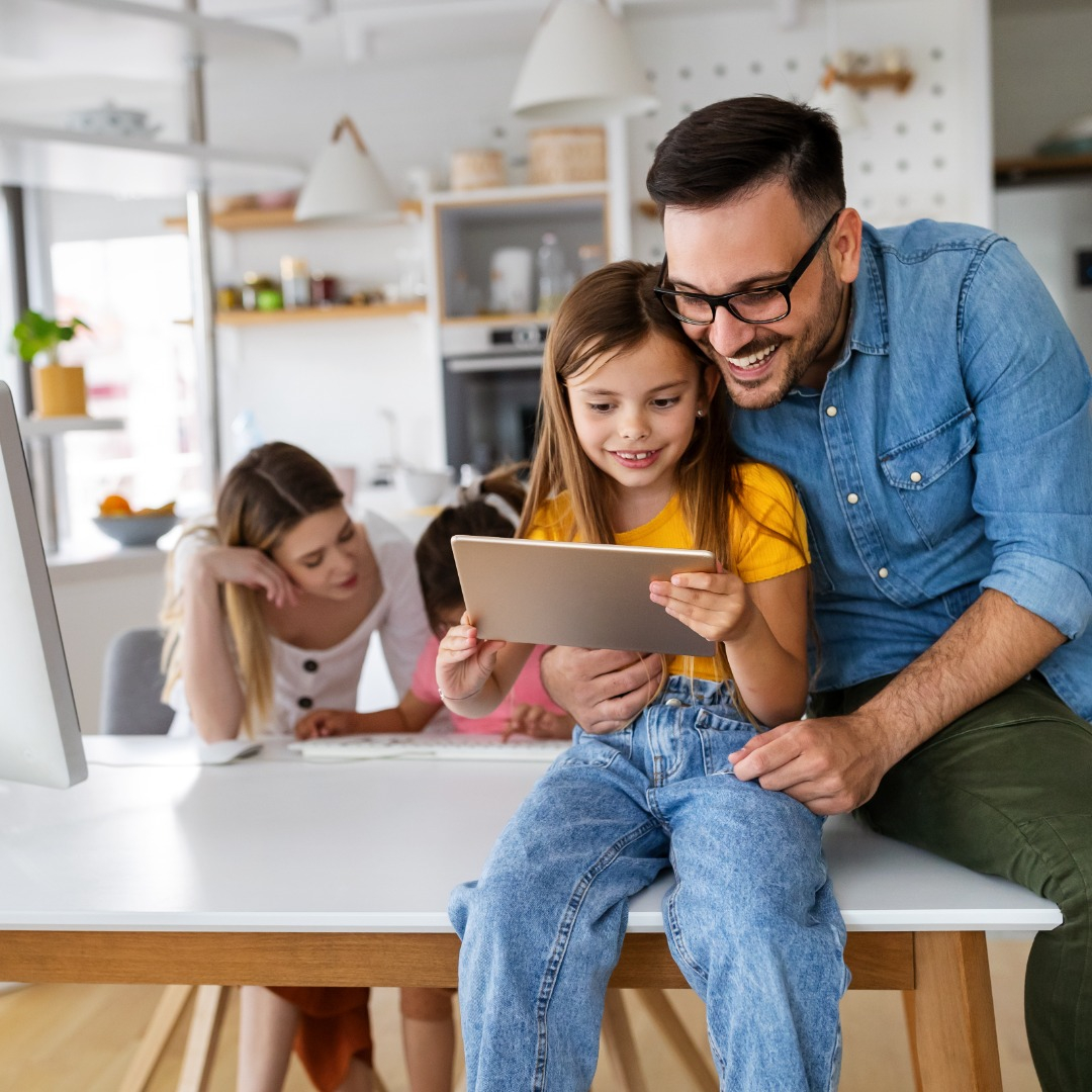 Family sat using a tablet device 